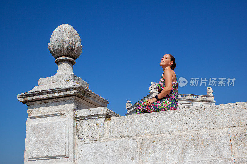 Tourist sunbathing at Praça do Comércio